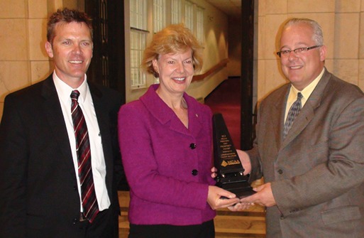 Jeff Buczkiewicz, MCAA President (r) presents Tammy Baldwin (D-WI) with the Freedom and Prosperity Award. Shown left is Joe Buechel, Natural Stone Veneers International.