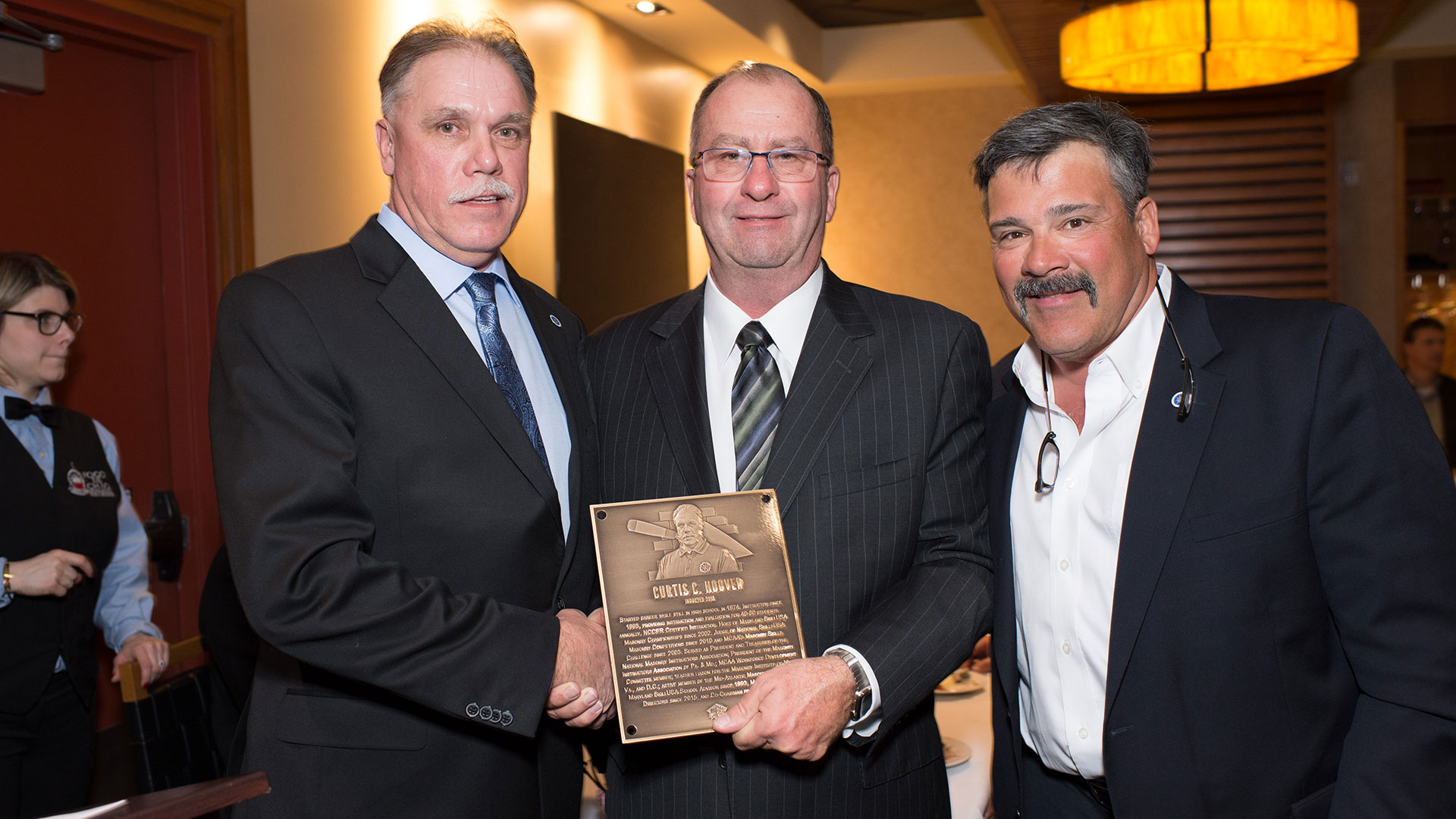 MCAA Chairman Mike Sutter (center) presents Curtis Hoover (left) with his Masonry Hall of Fame plaque.