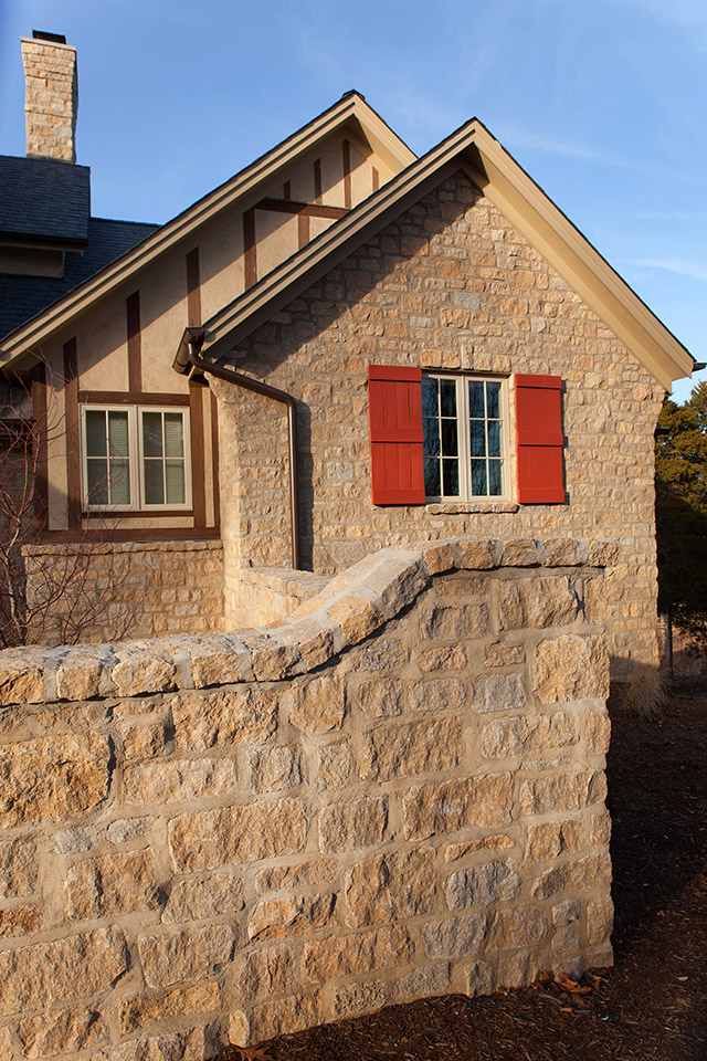 This garden wall of EW Gold limestone surrounds the home’s front entrance.