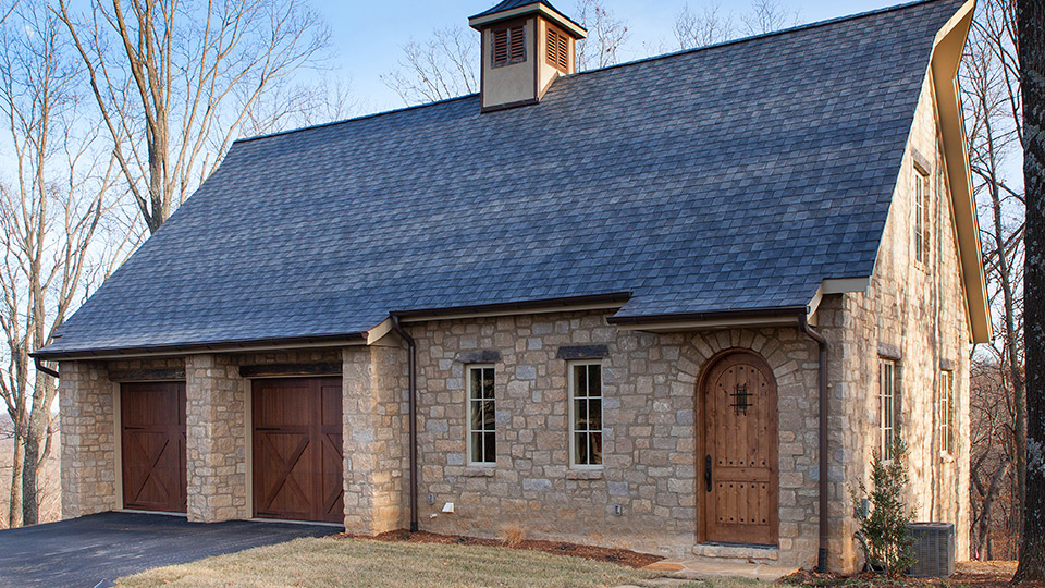 A multi-level “bank barn” built into a hillside complements the old world feel of the house by using the same combination of EW Gold limestone block, brushed mortar and antique timber that is used on the house.